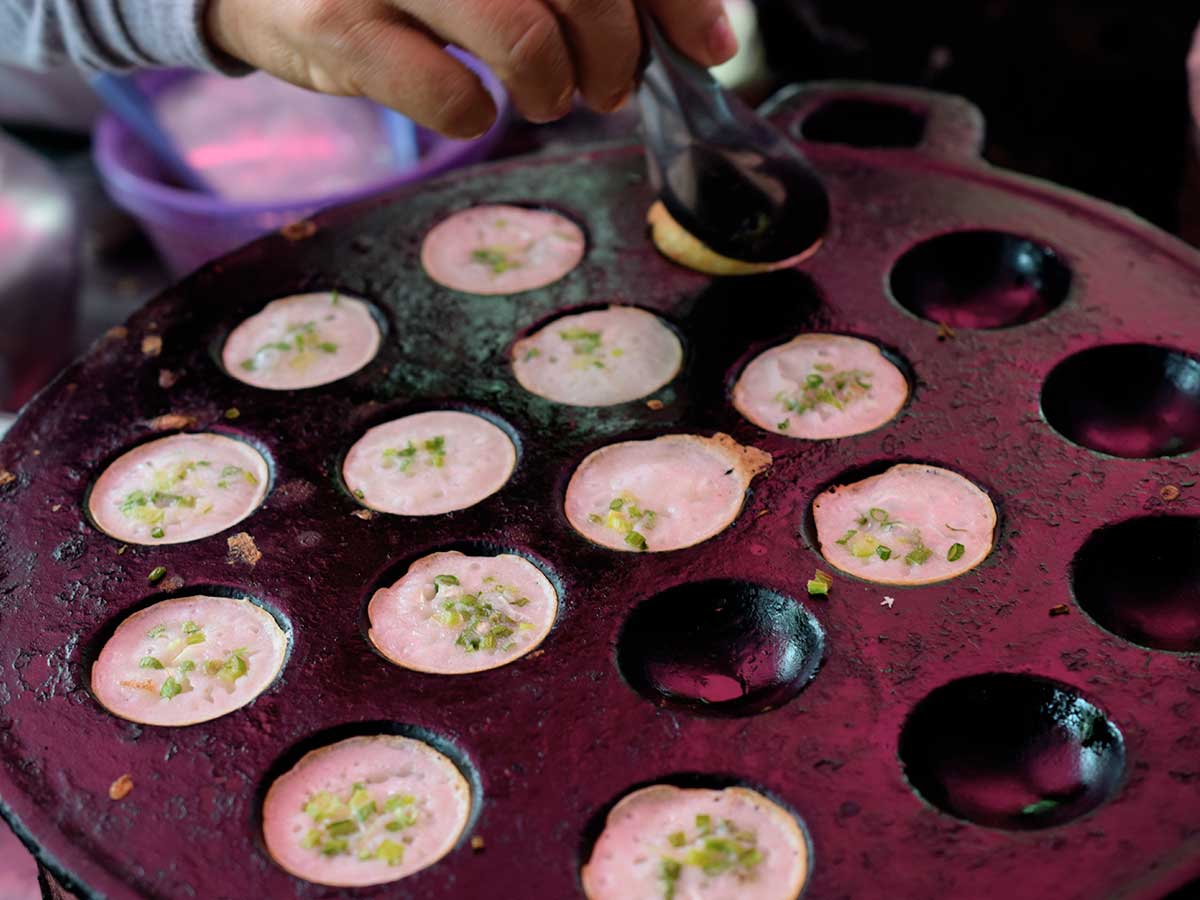 best thai street food kanom krok with scallions cooking in griddle the food quest