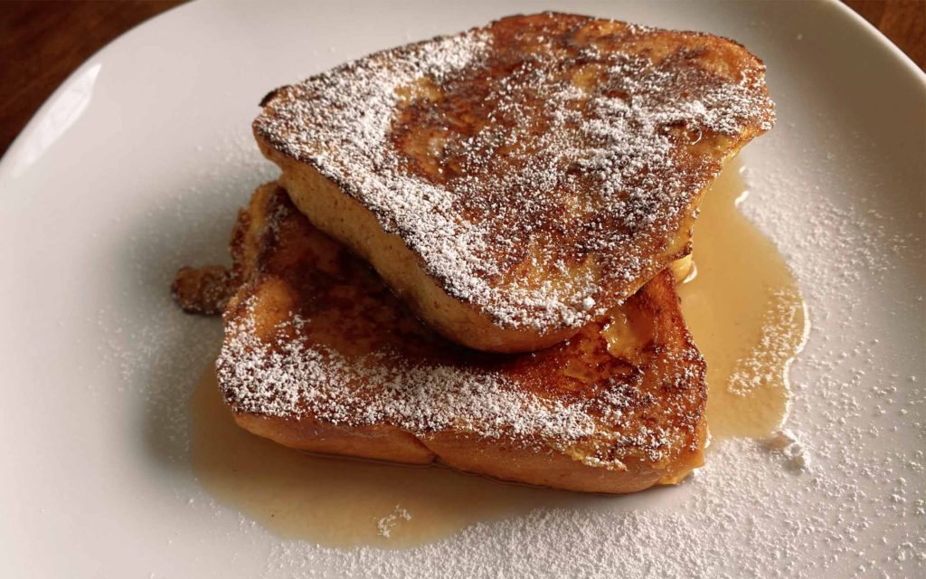 homemade french toast with syrup and powdered sugar