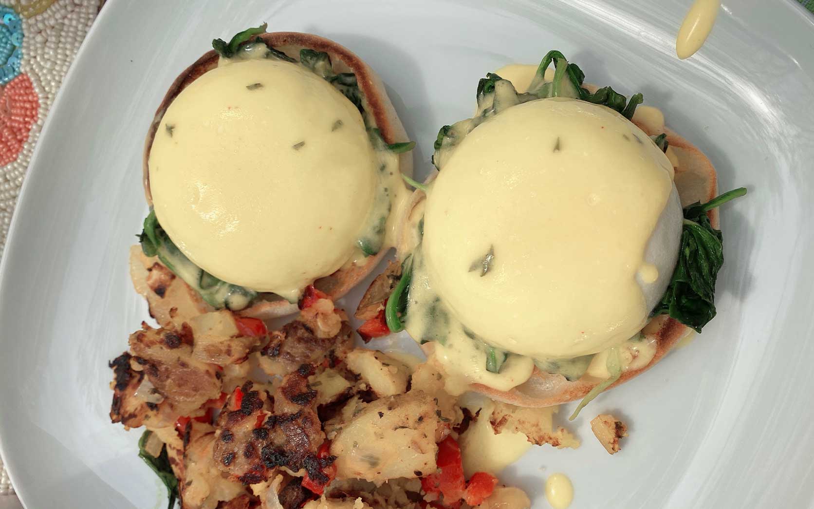 hollandaise eggs benedict with spinach and hashbrowns