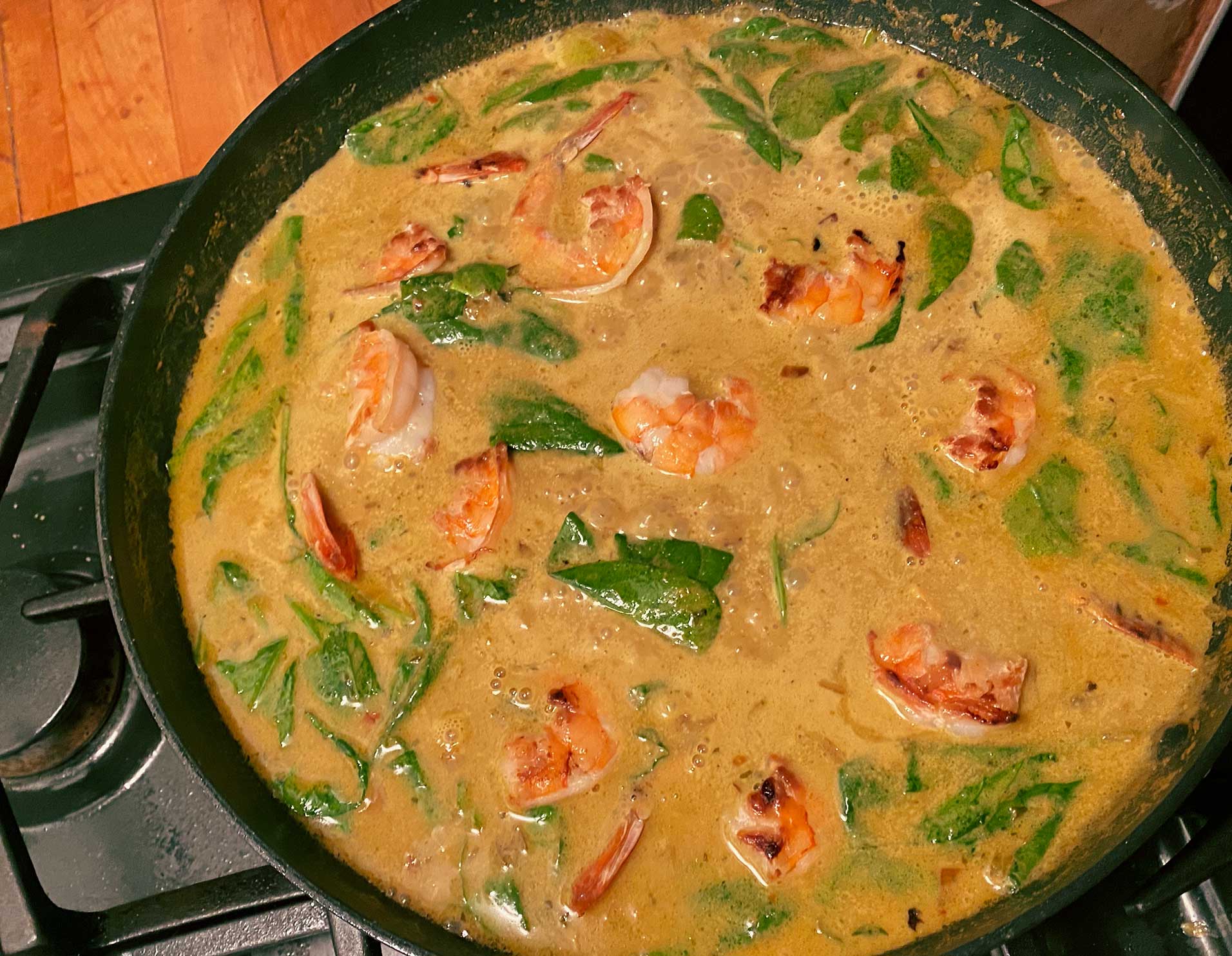 thai shrimp coconut curry with spinach in a pan